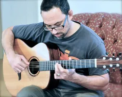 Anton sitting on the couch with his Alberico guitar