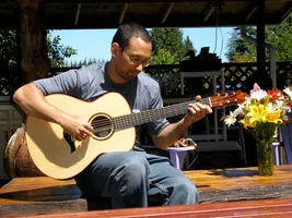Anton sitting outside in the sun with his Alberico guitar