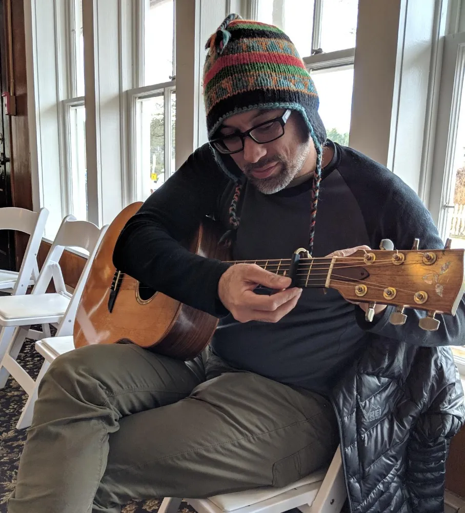 Anton putting a capo on his Goodall guitar