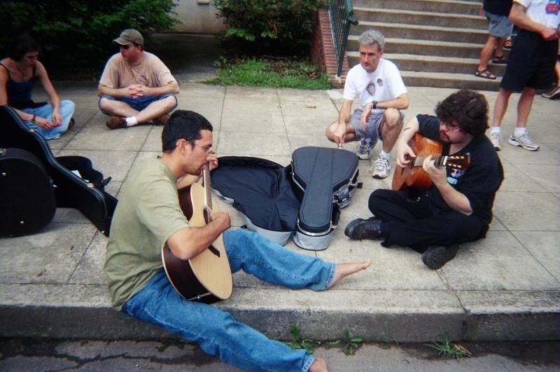 William and Anton playing guitar on the sidewalk